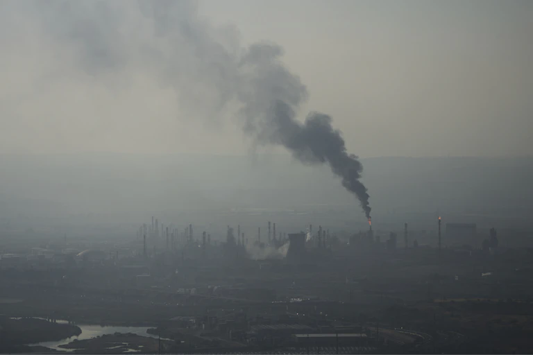 an obscured skyline can be seen as smoke rises