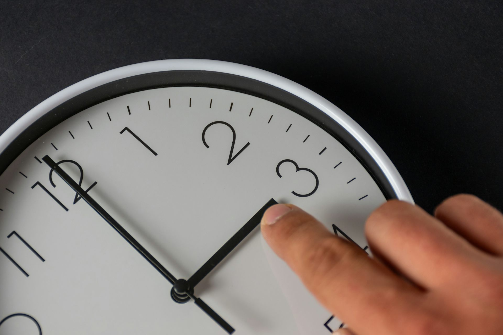 Un dit ajusta les agulles d'un rellotge.