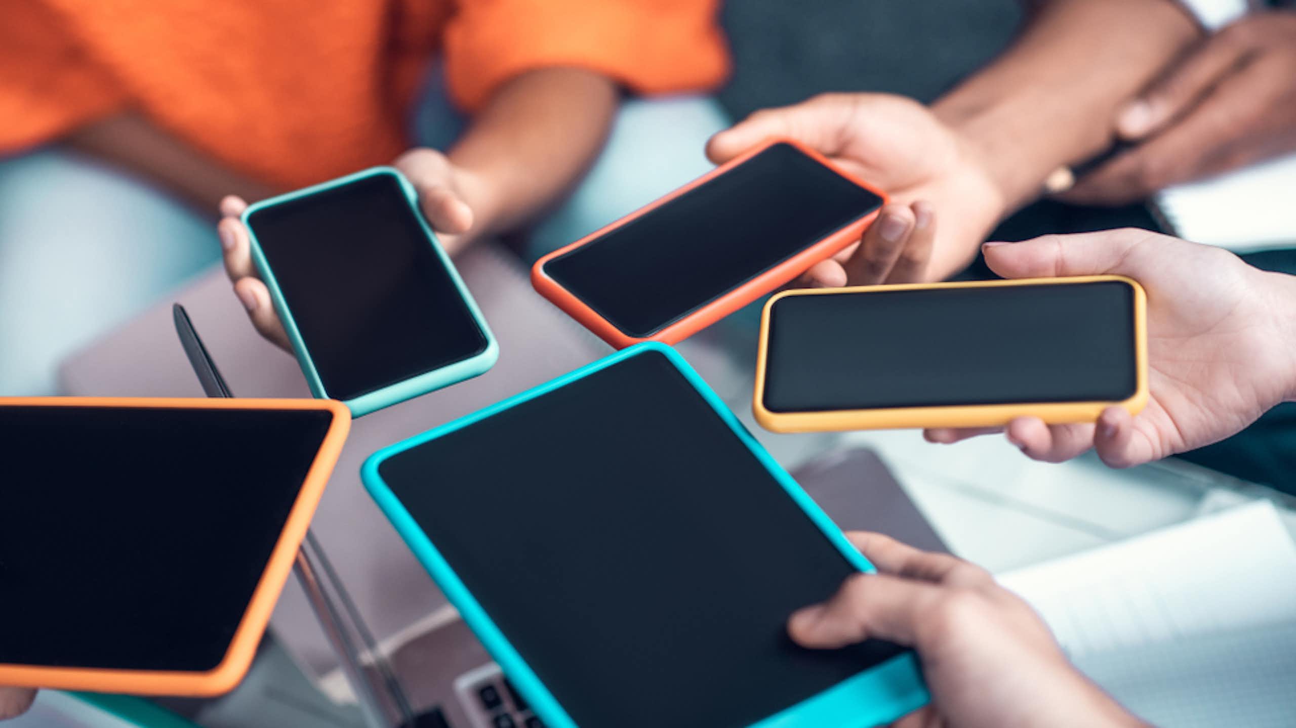 Des adolescents tenant leurs smartphones.