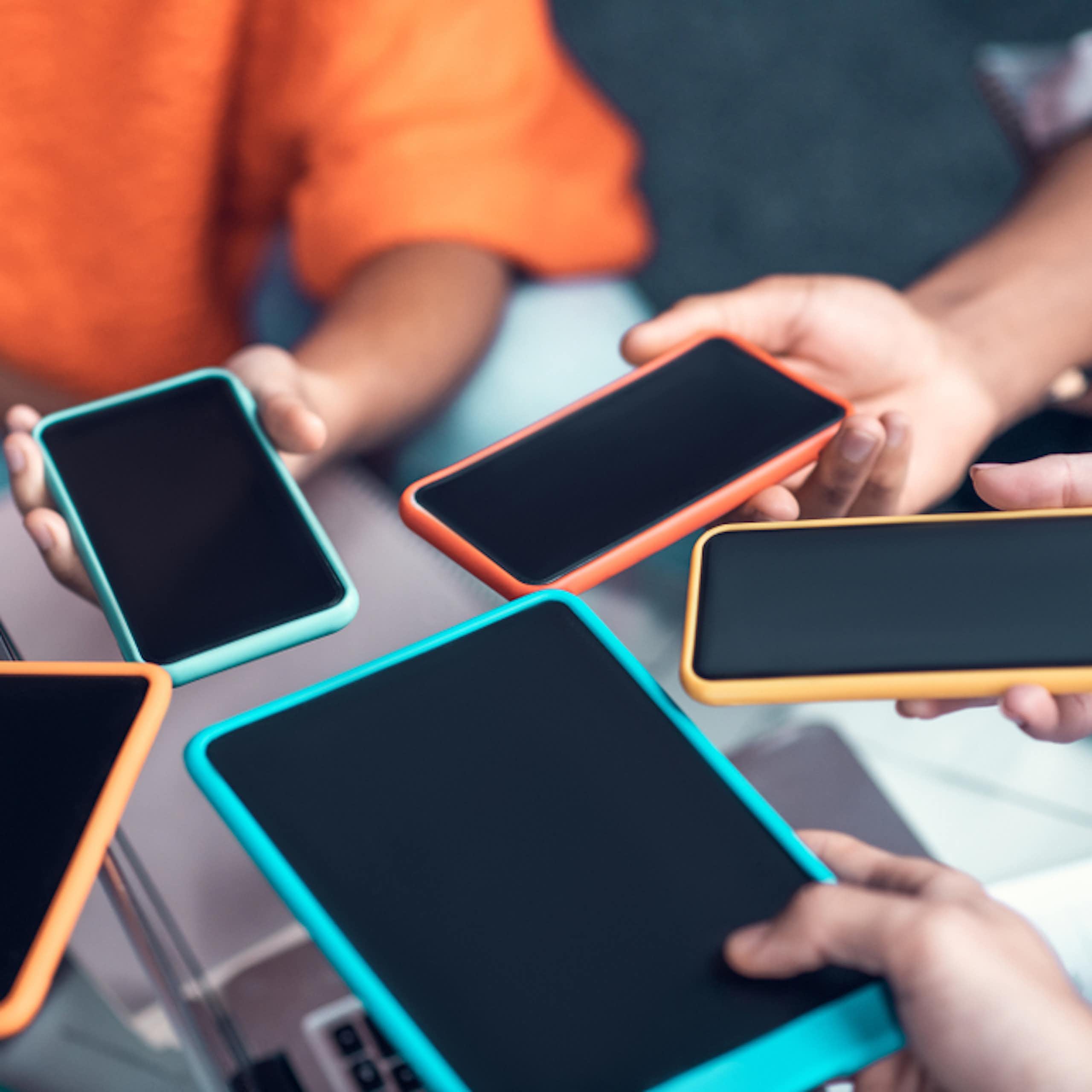 Des adolescents tenant leurs smartphones.