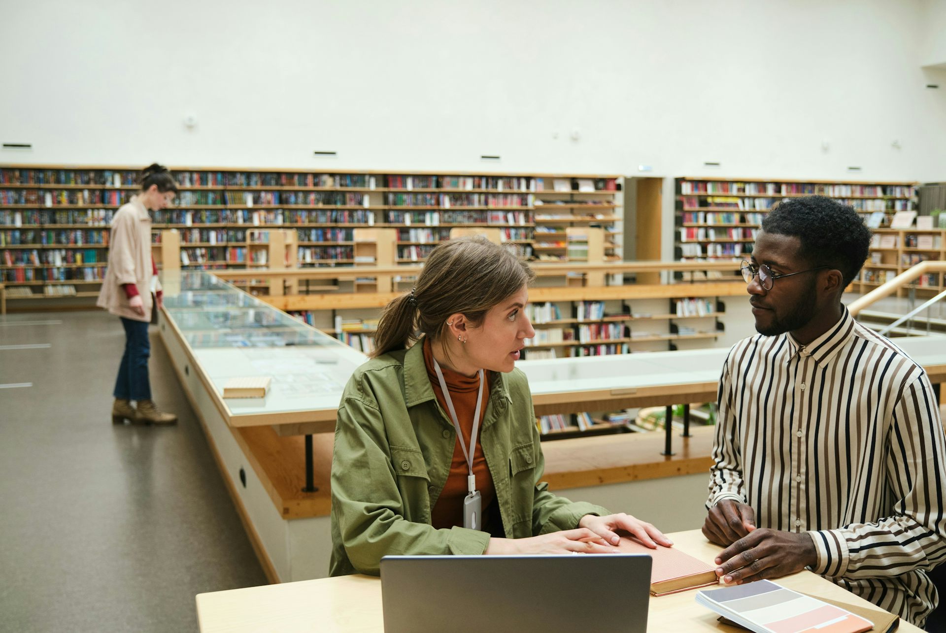 Dos personas discutiendo en la biblioteca.