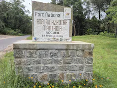 A stone sign bearing the park's name next to the road.