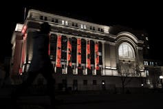 Amapolas rojas proyectadas sobre el ornamentado edificio de piedra.