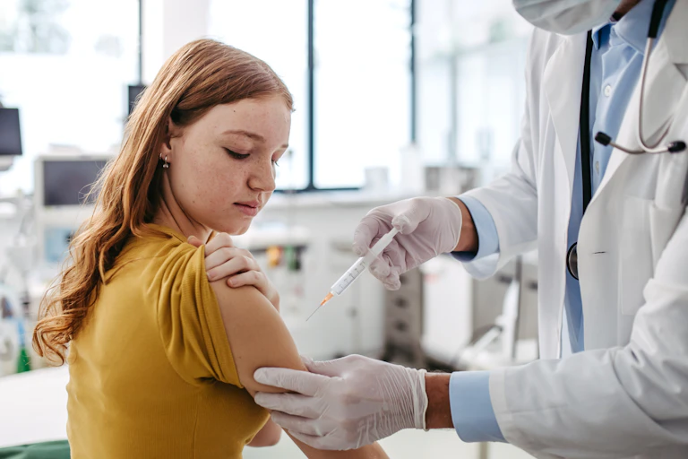 Doctor injecting HPV vaccine into girl's arm