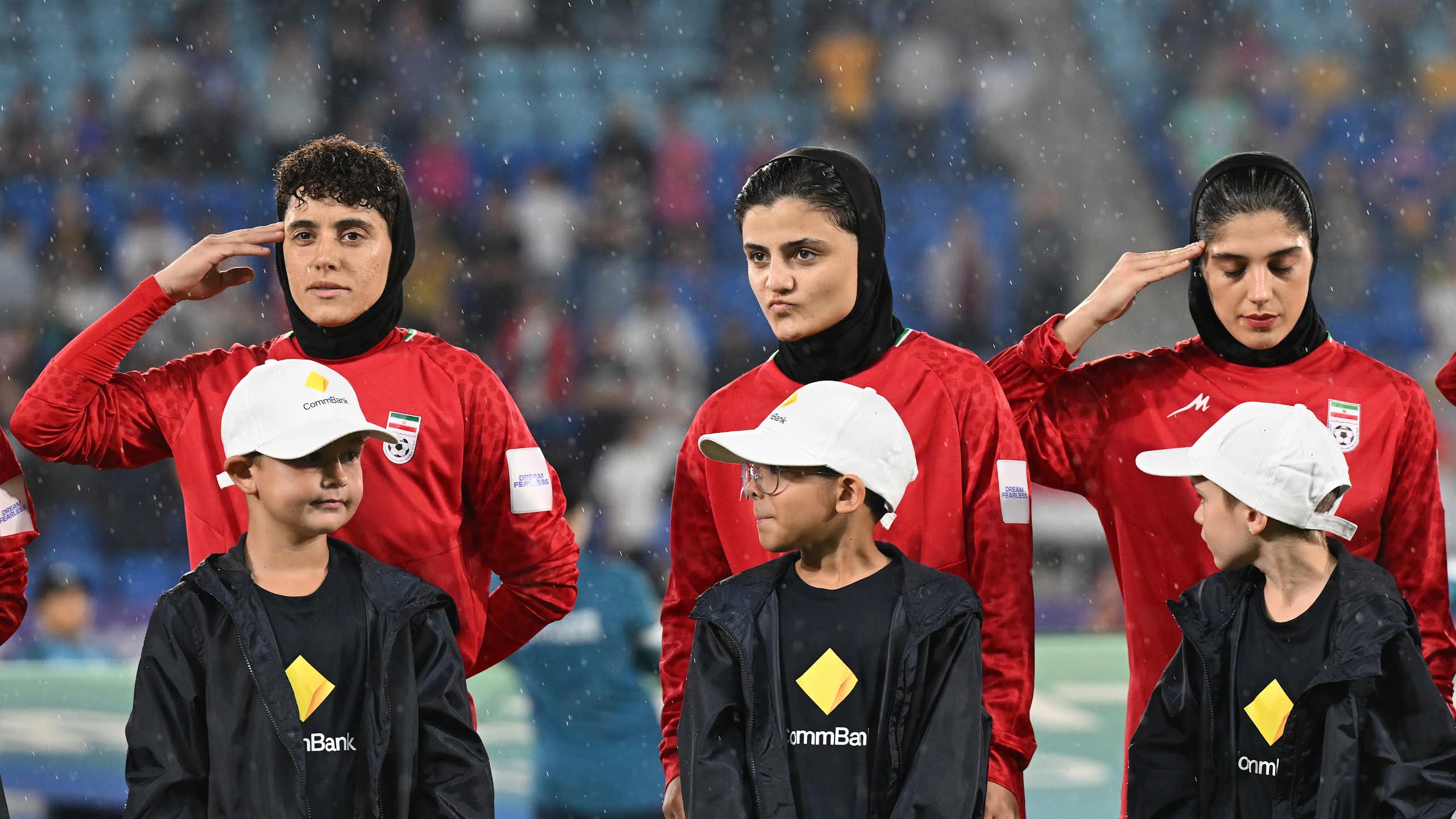 Some members of the Iran women's soccer team salute during the national anthem ahead of an Asian Women's Cup game.