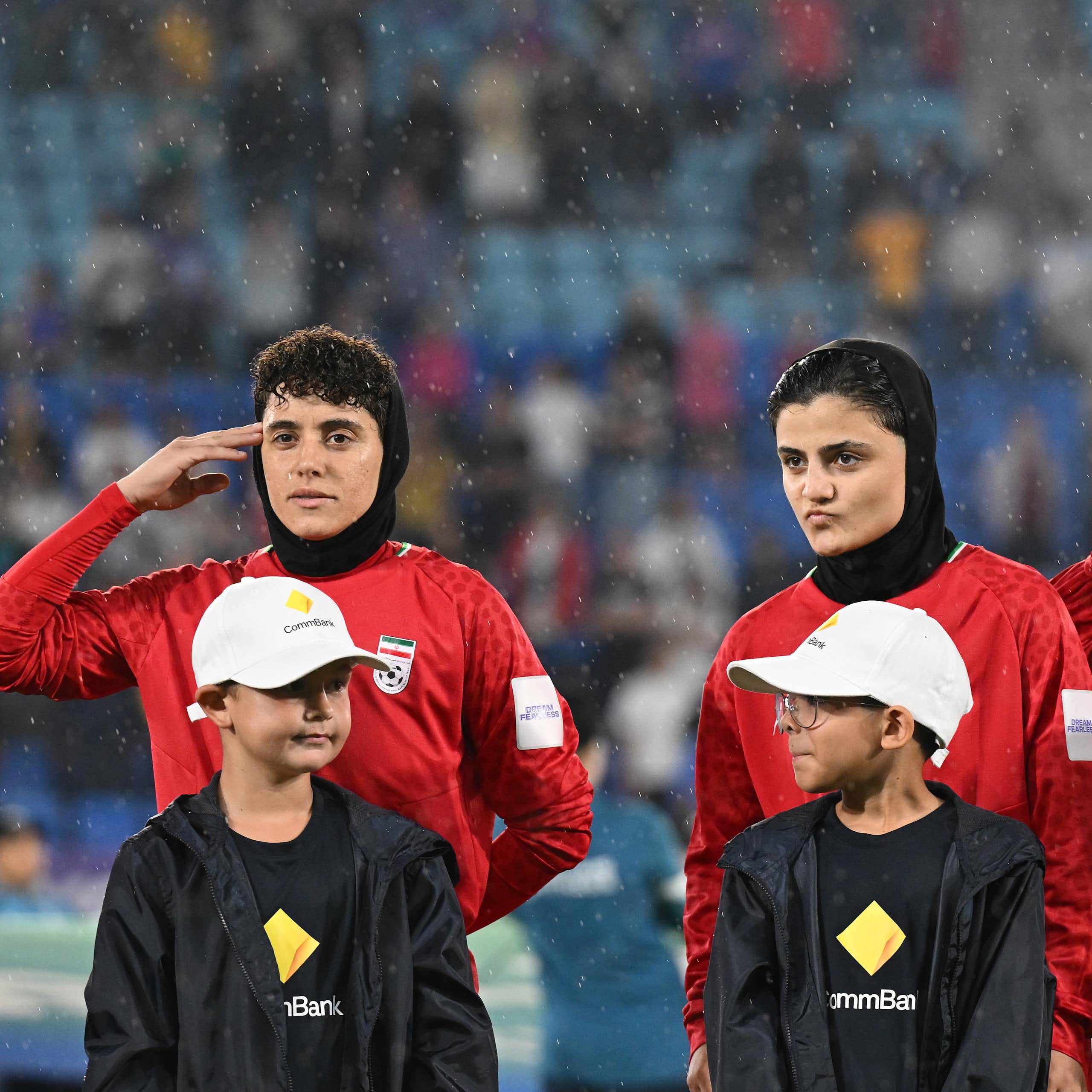 Some members of the Iran women's soccer team salute during the national anthem ahead of an Asian Women's Cup game.
