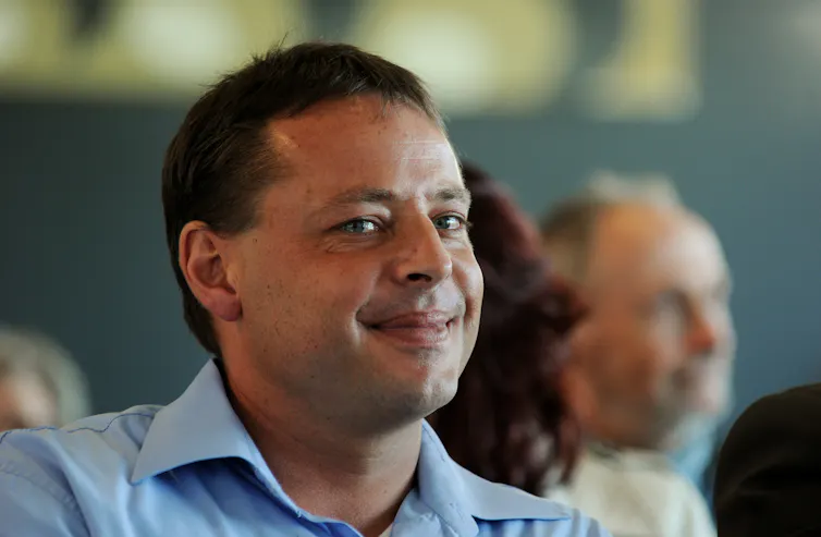 A smiling man in a blue shirt