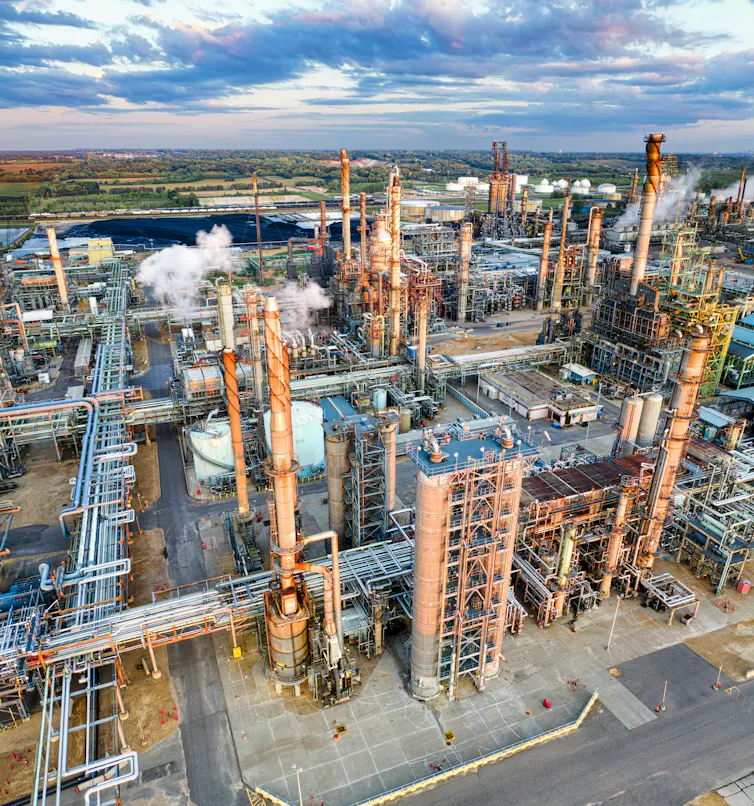oil refinery seen from air. smokestacks with smoke, complex industrial buildings.