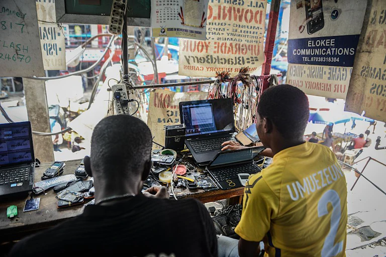 Two men in an electronics repair shop.