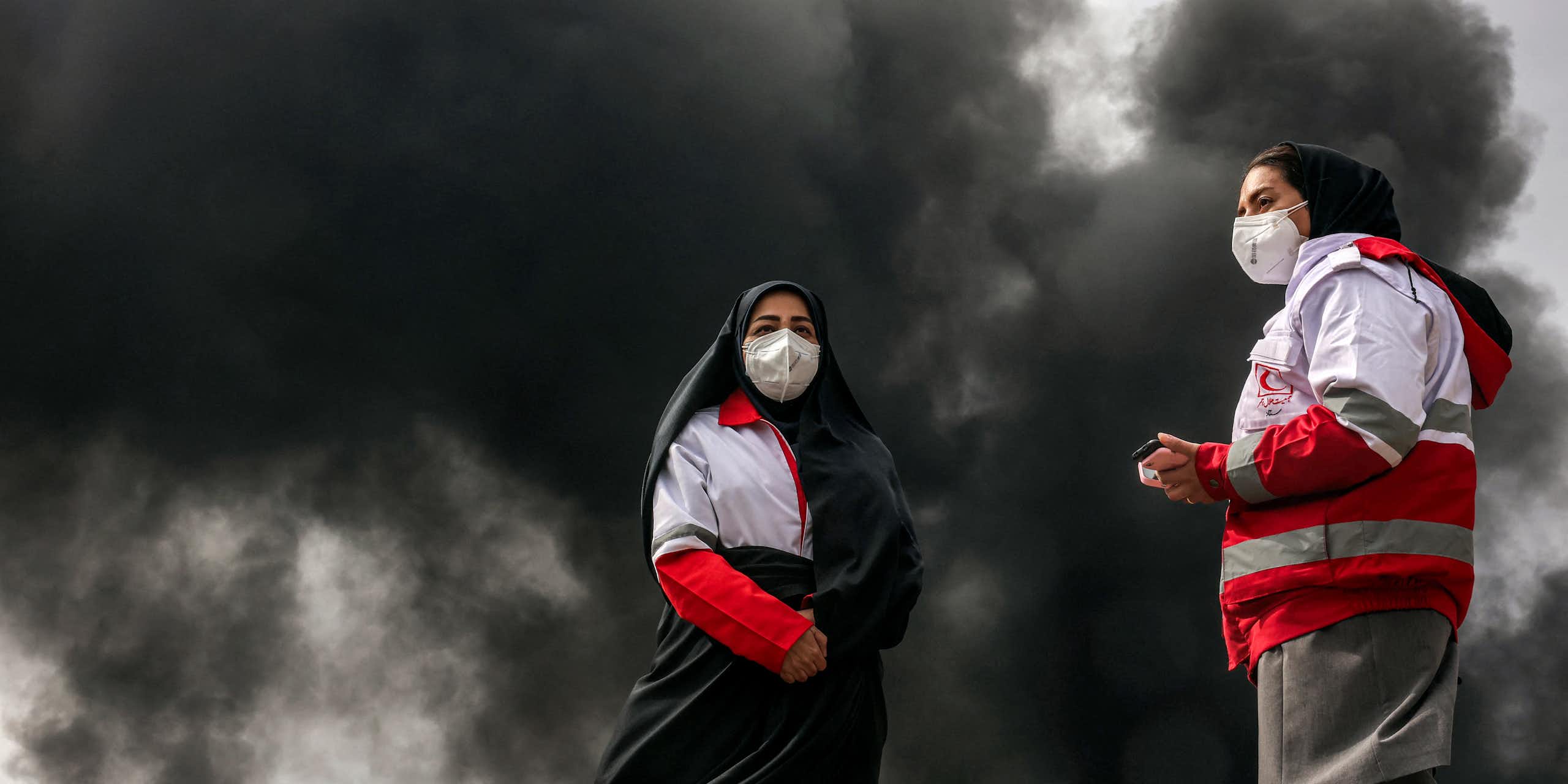 Vue en pied des deux femmes secouristes portant des masques.