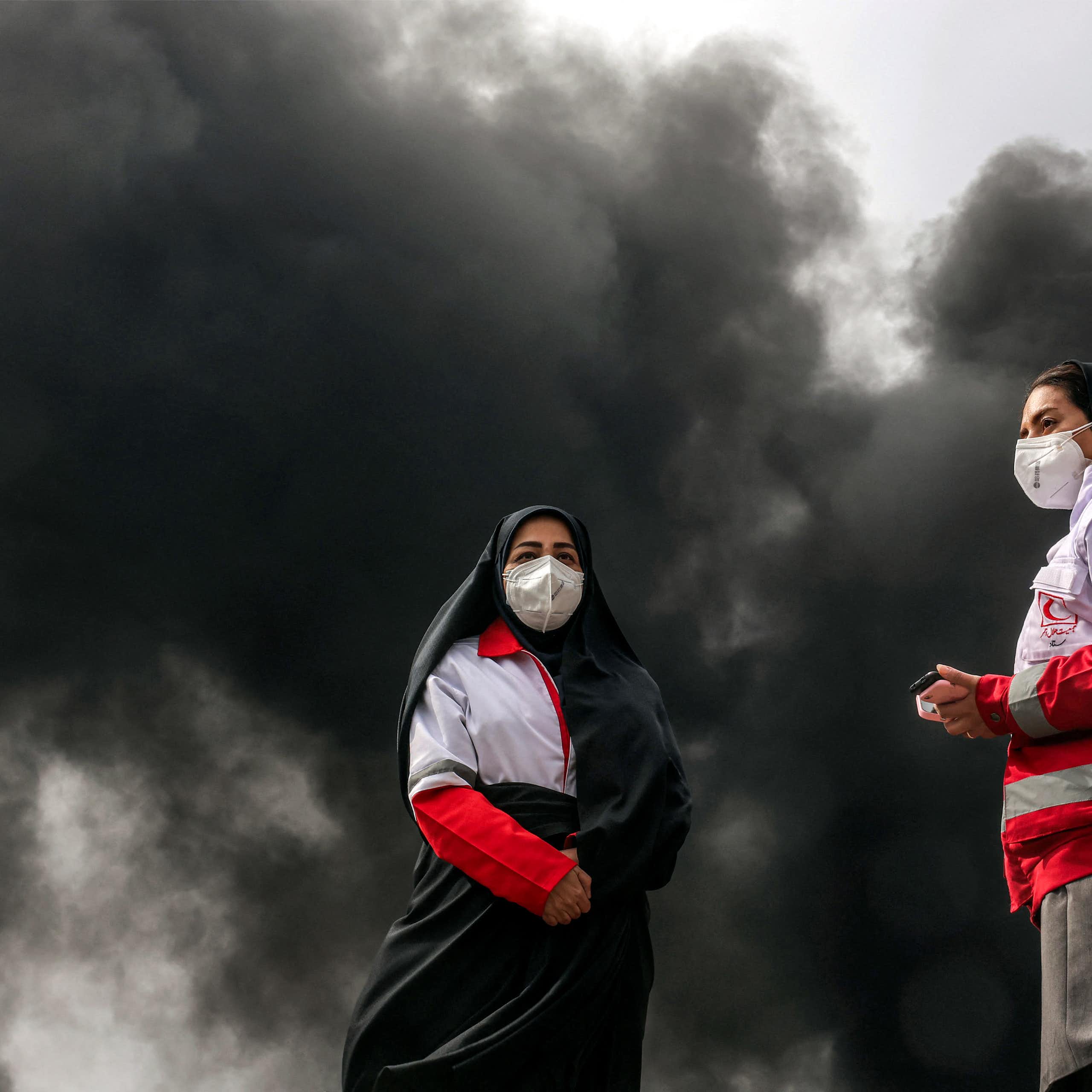 Vue en pied des deux femmes secouristes portant des masques.