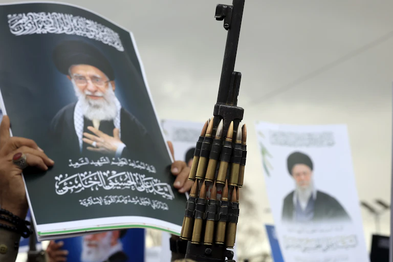 Houthi supporters in Yemen hold up guns and portraits of Ayatollah Ali Khamenei.