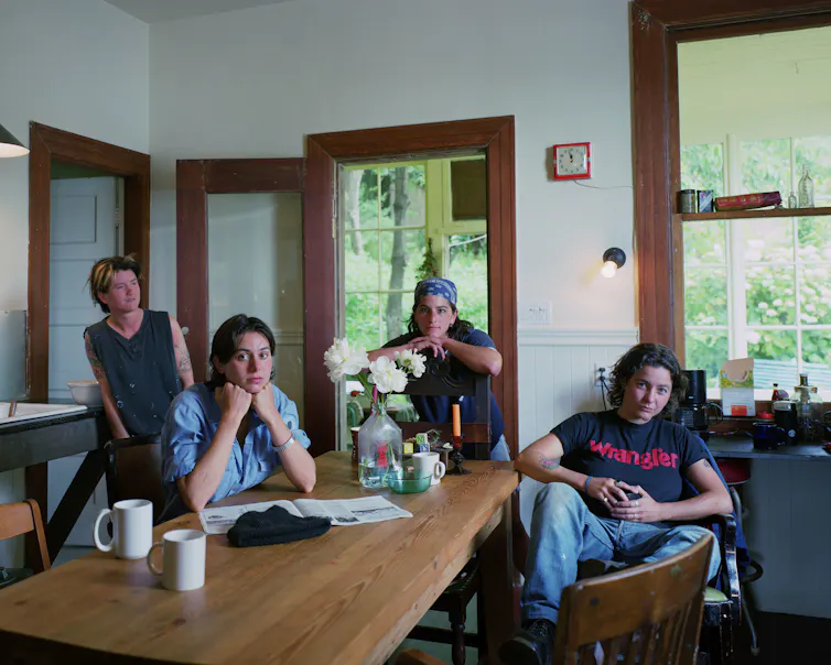 Portrait of four people sat in a kitchen