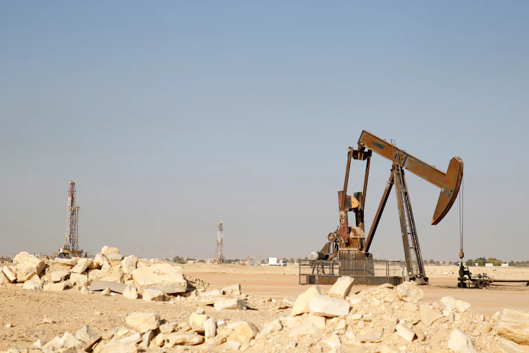 Pump jack and drill tower in desert, Oman