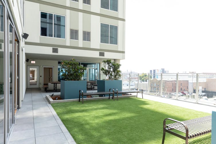 An apartment building with a rectangular green space is shown.