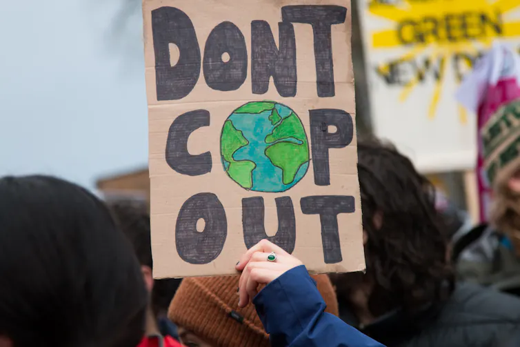 person holds 'don't cop out' placard