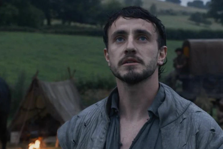 A young, handsome, forlorn-looking man stares off into the distance.
