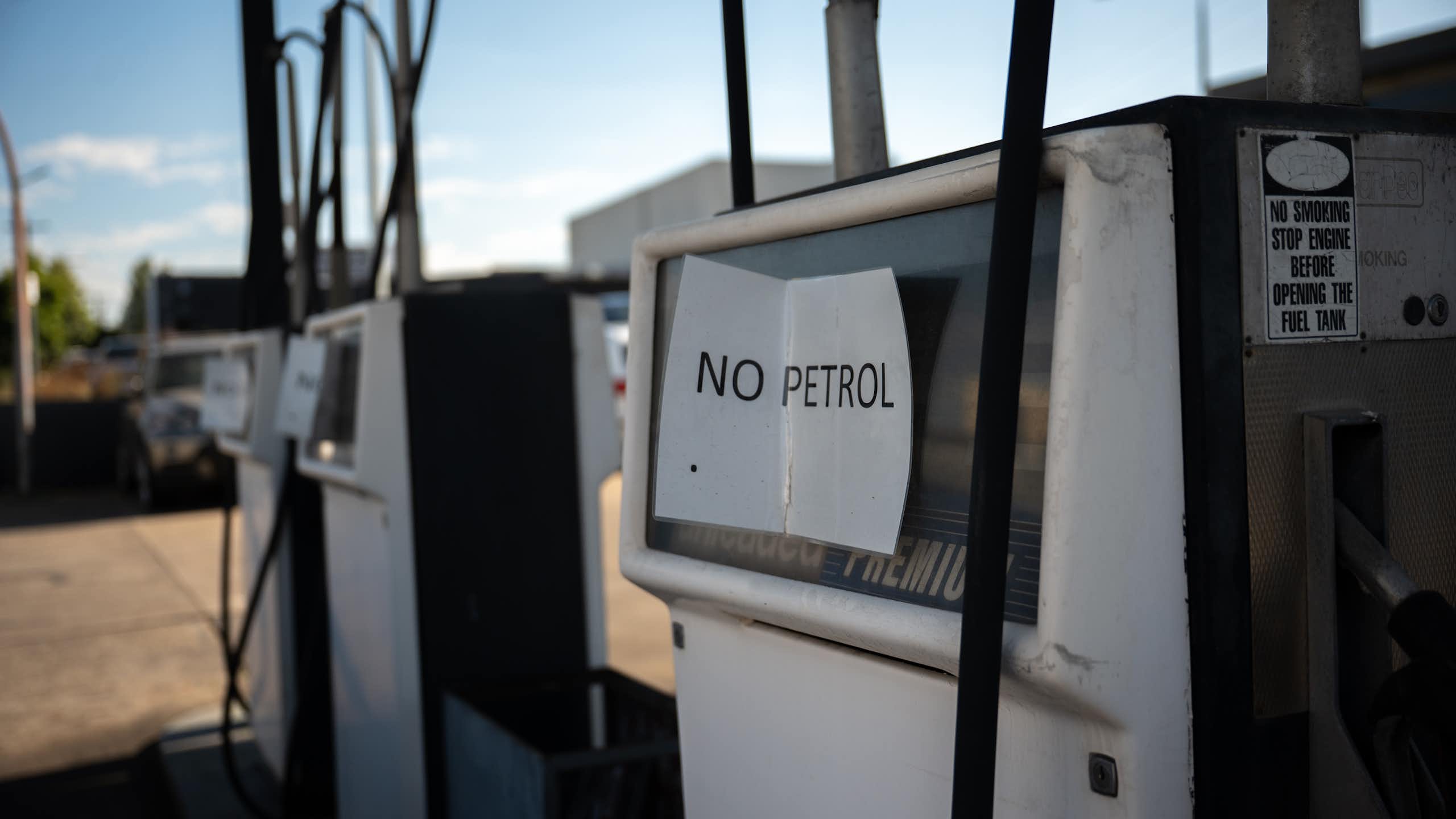 Empty fuel pumps at a service station, sign which reads no petrol