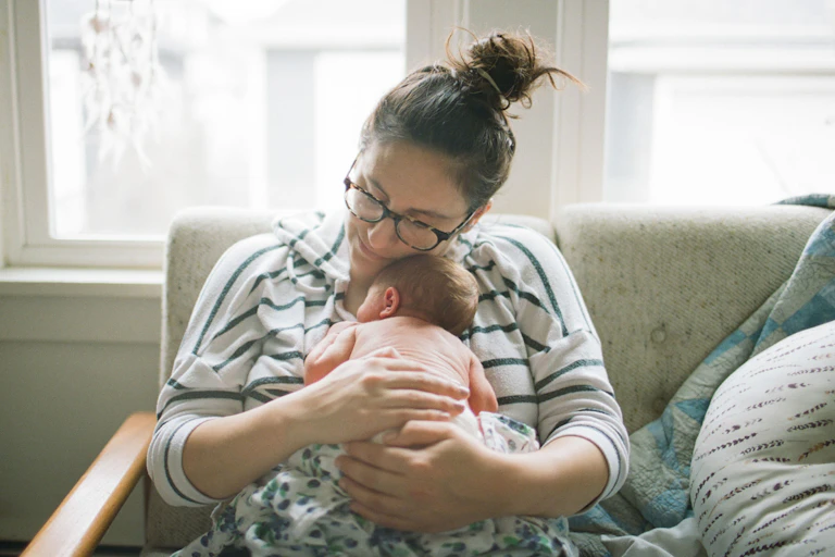 Woman cuddling little baby.