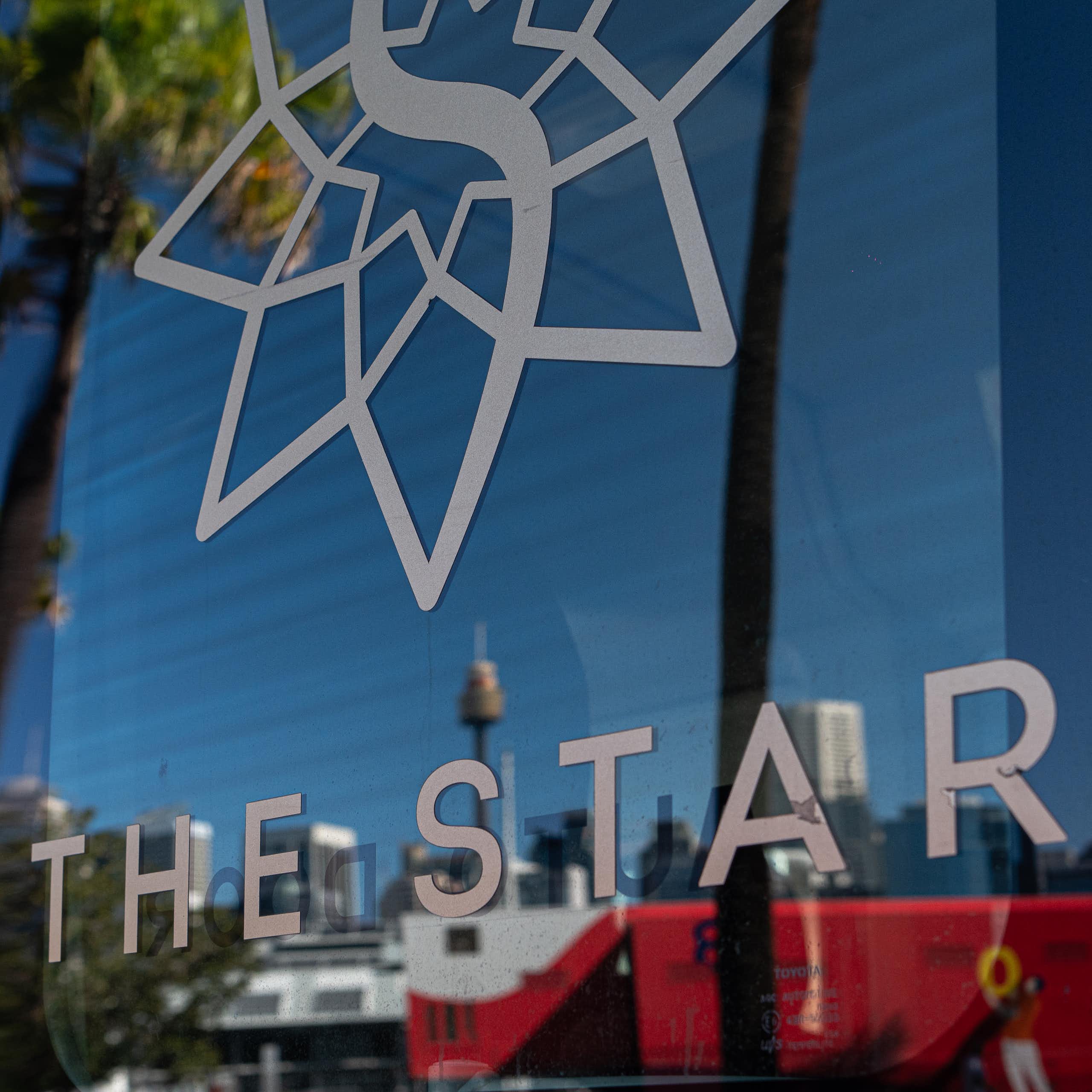 A close up of Sydney's Star casino logo, with the Sydney's skyline in the background