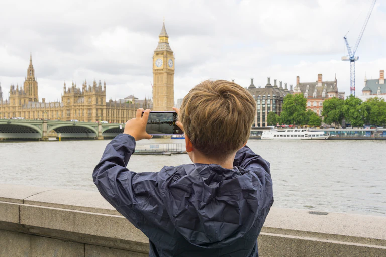 Child taking photo on phone of Palace of Westminster