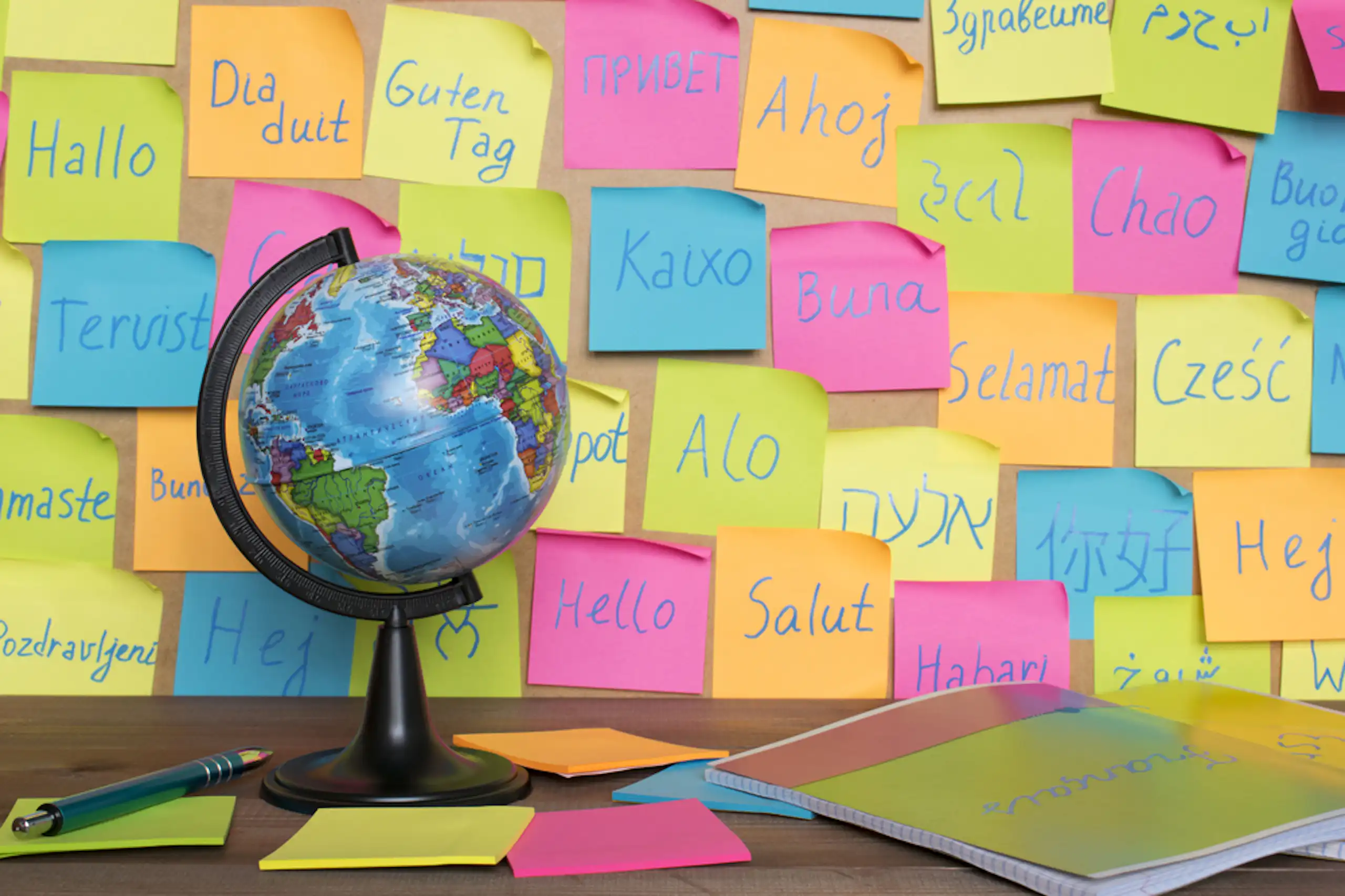 Une mappemonde avec des post-it sur lesquels sont écrits des mots dans différentes langues