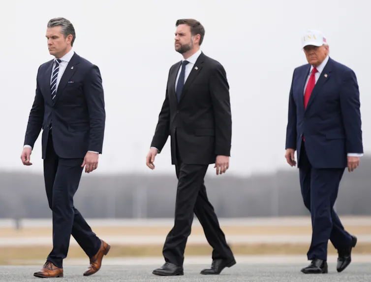 Three suited men walking