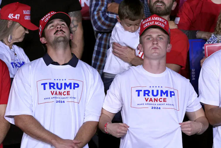two young men in Trump Vance t-shirts and MAGA caps