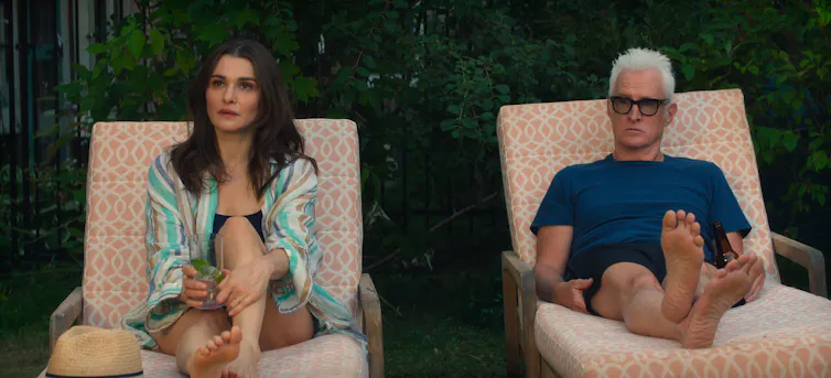 a woman and man on pool lounges