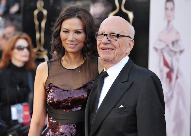 an old man in a suit with a beautiful woman in evening dress