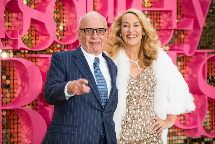 an old man in a suit with an older, well preserved, blonde woman in a sparkly evening gown