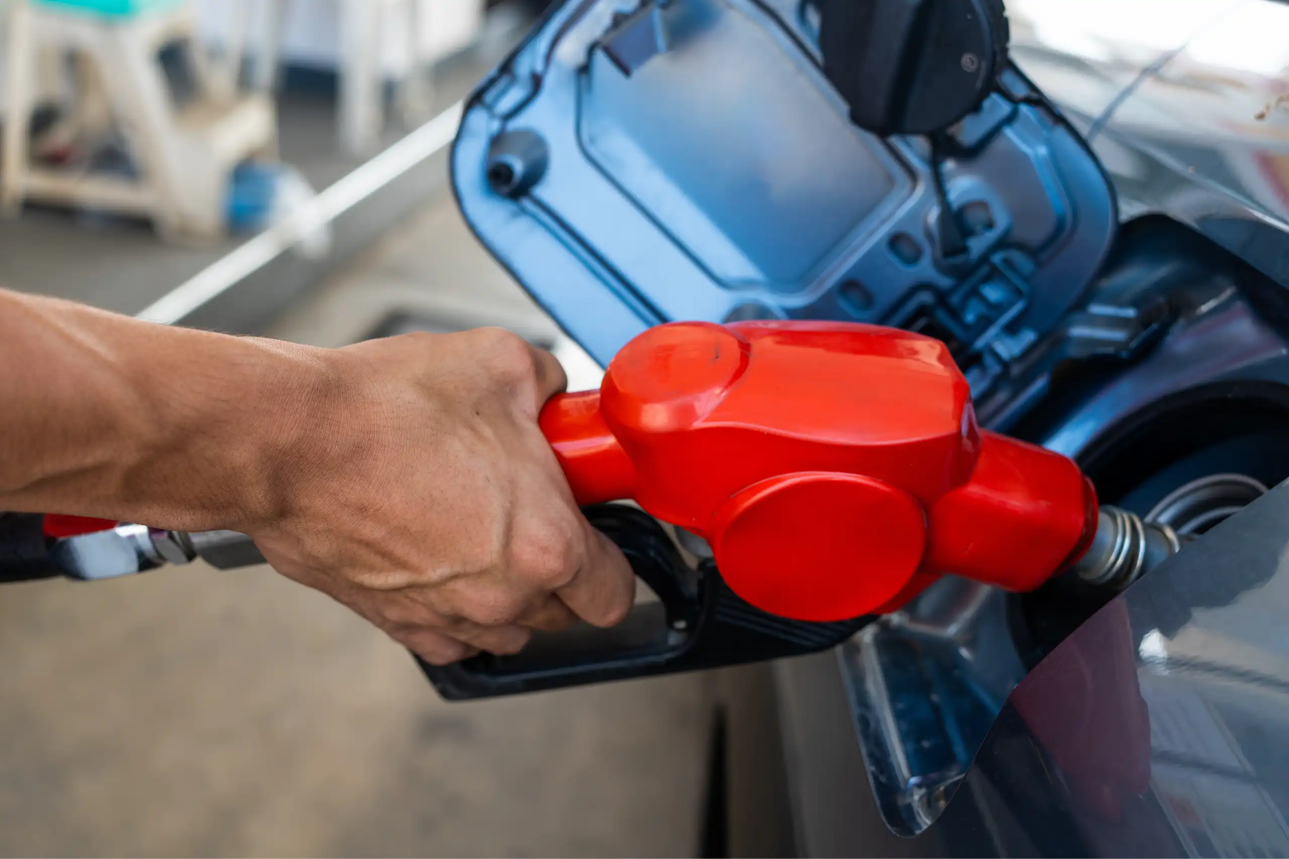 Una mà posa benzina a un dipósit de cotxe.