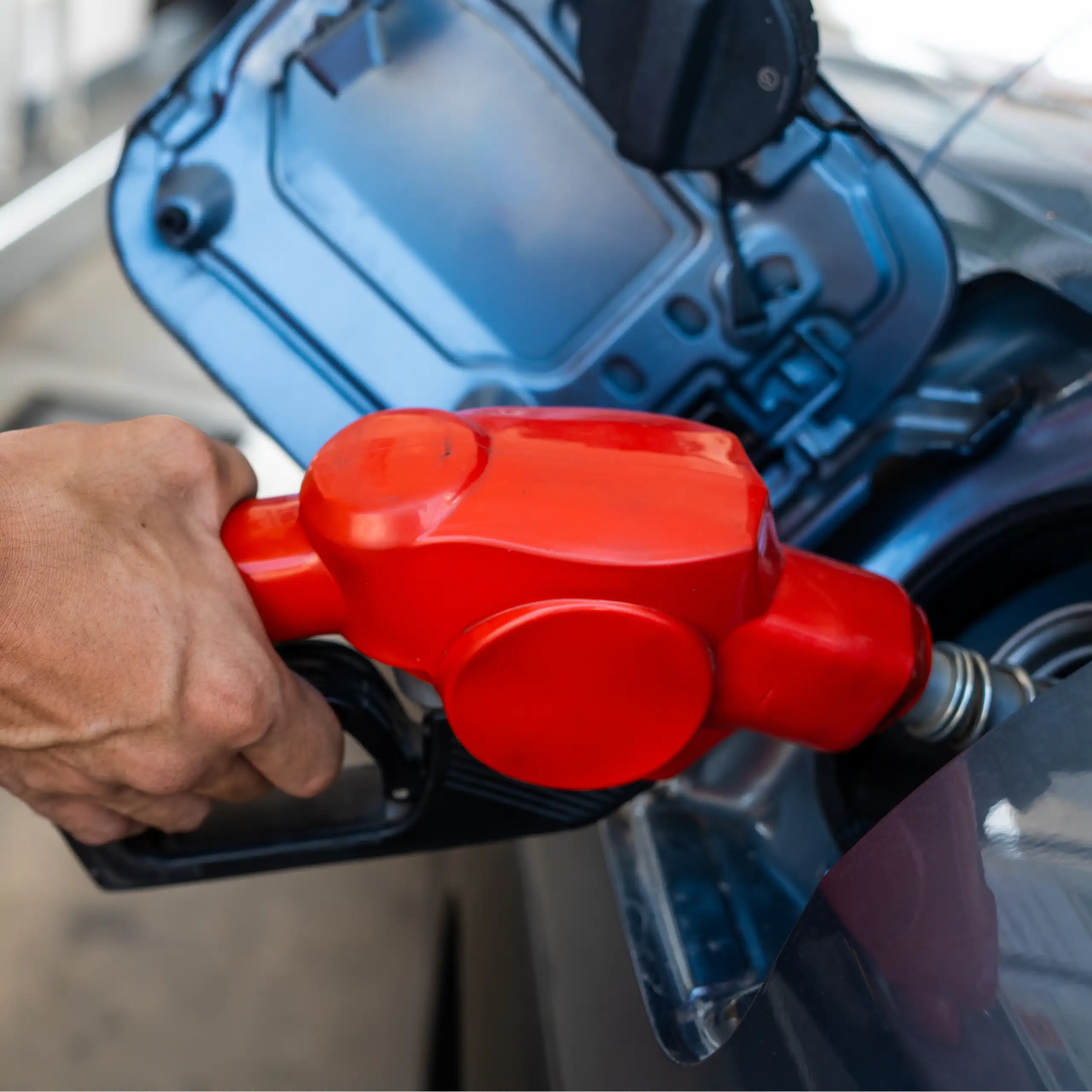 Una mà posa benzina a un dipósit de cotxe.