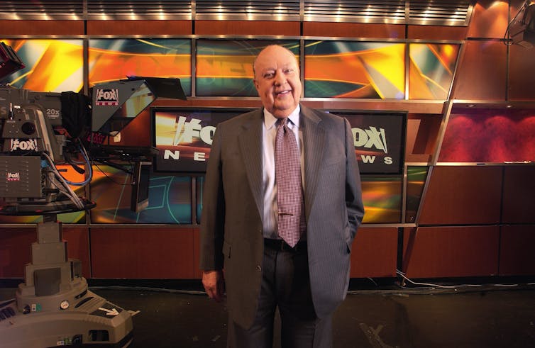 a man in a suit in front of a Fox News set