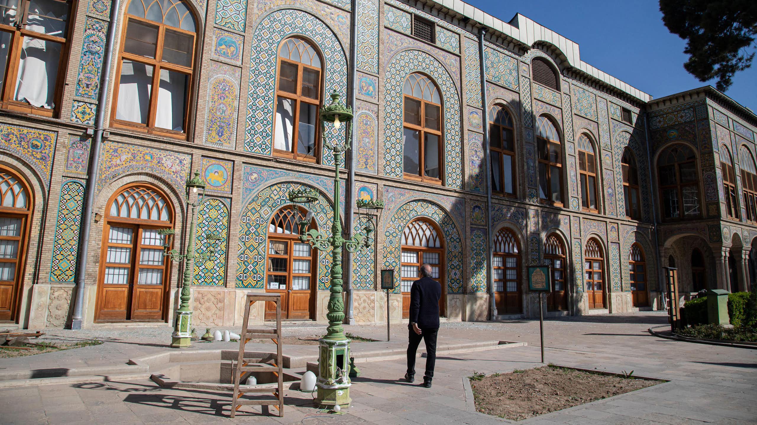 A man walks past debris scattered across the floor of Golestan Palace.