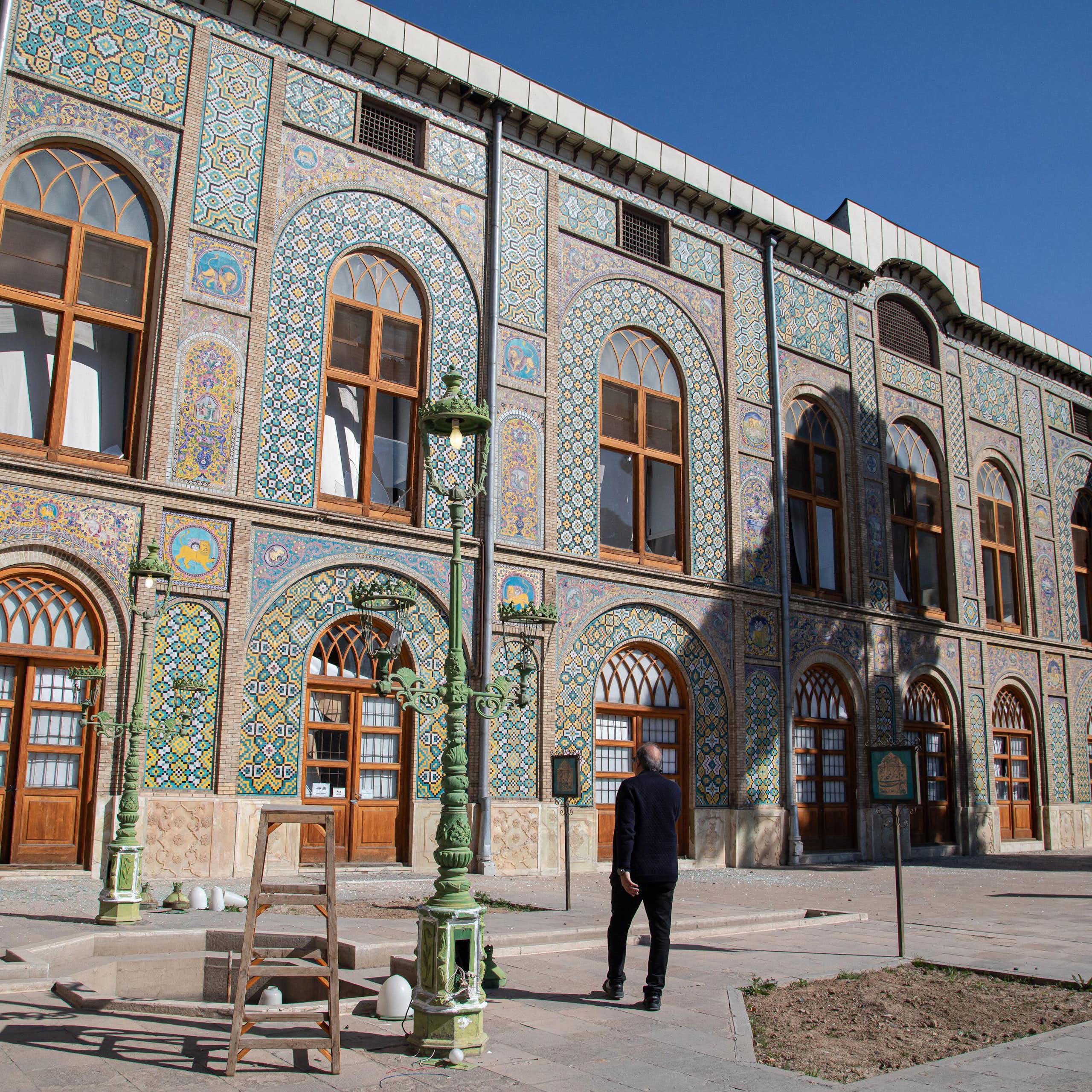 A man walks past debris scattered across the floor of Golestan Palace.