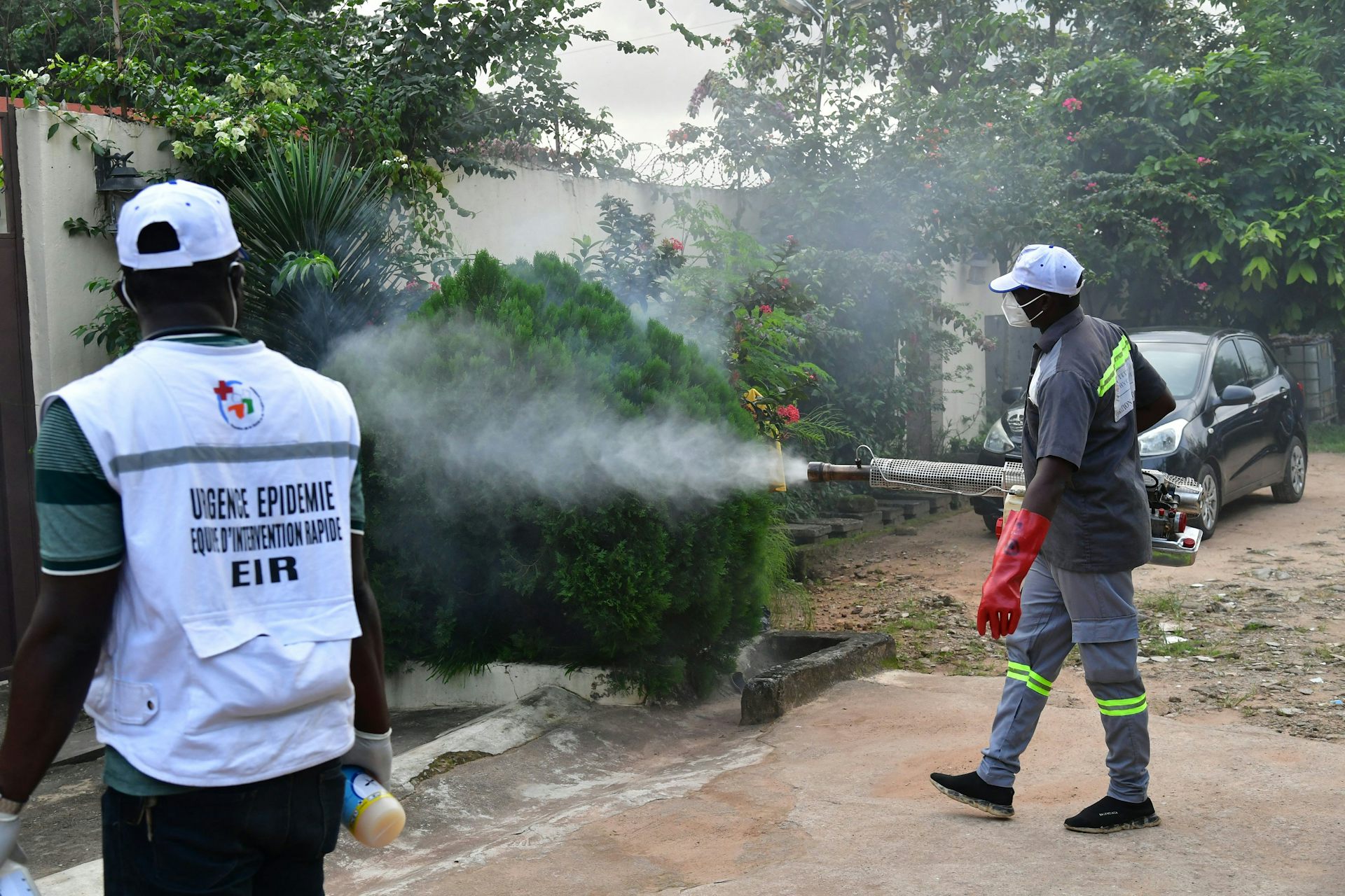 Two men spraying the environment 