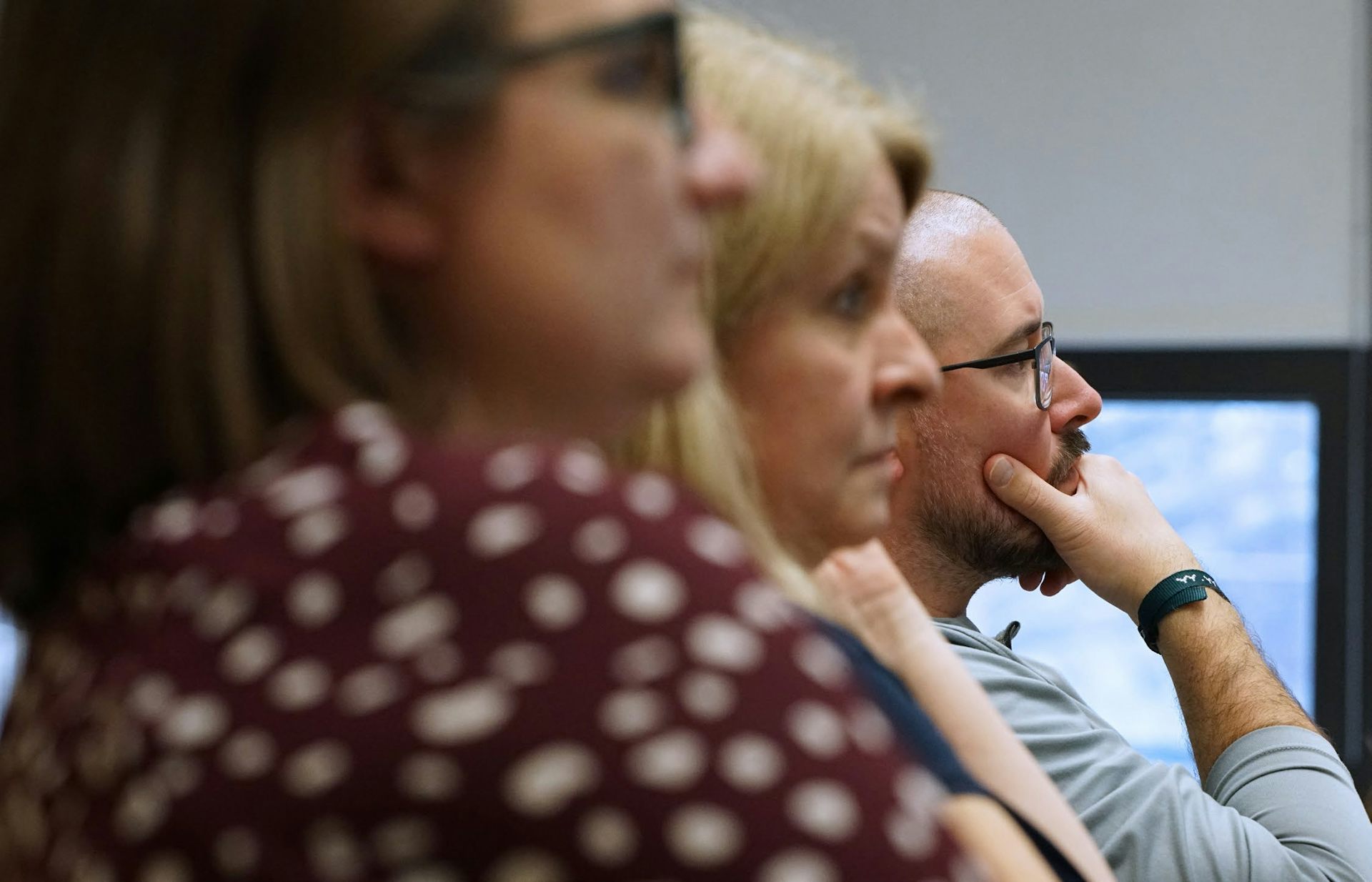Al costado, puedes ver a tres personas mirando hacia adelante en la misma dirección.