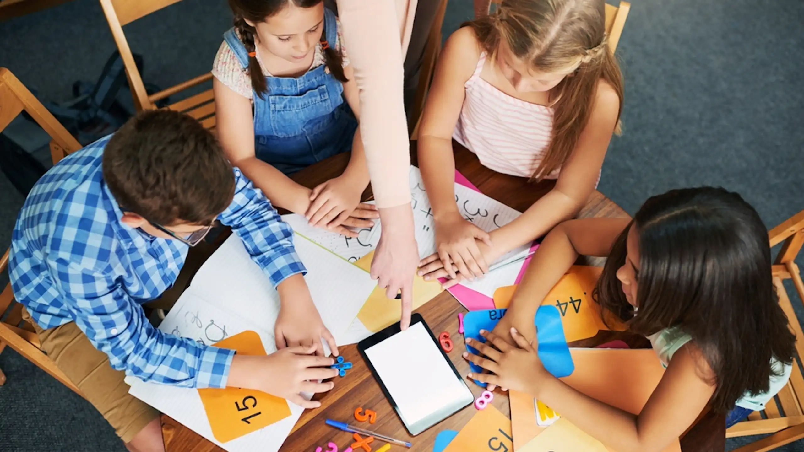 Des enfants en train de résoudre des questions mathématiques autour d'une table.