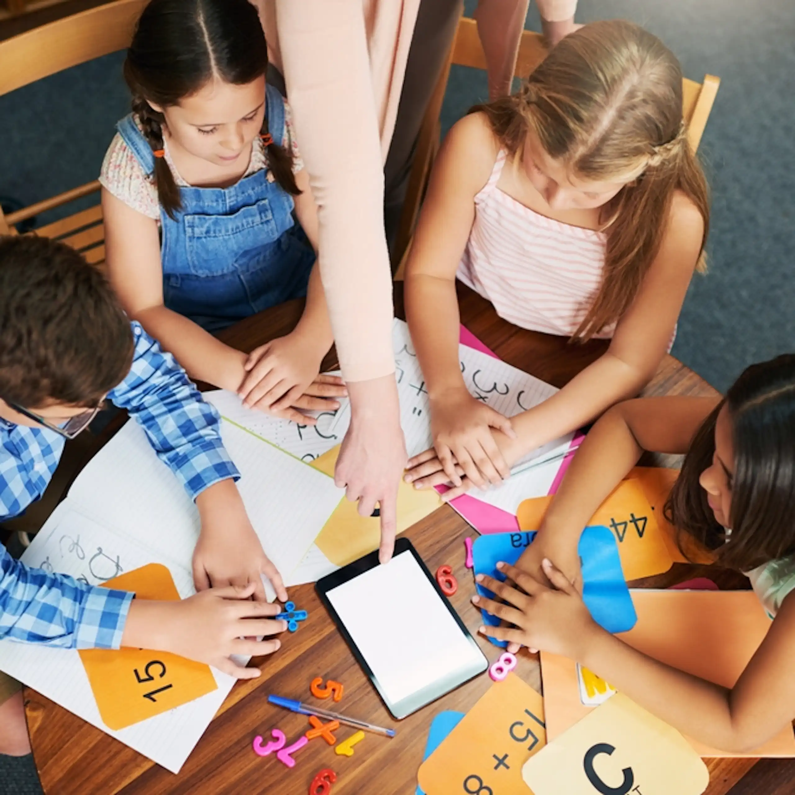 Des enfants en train de résoudre des questions mathématiques autour d'une table.