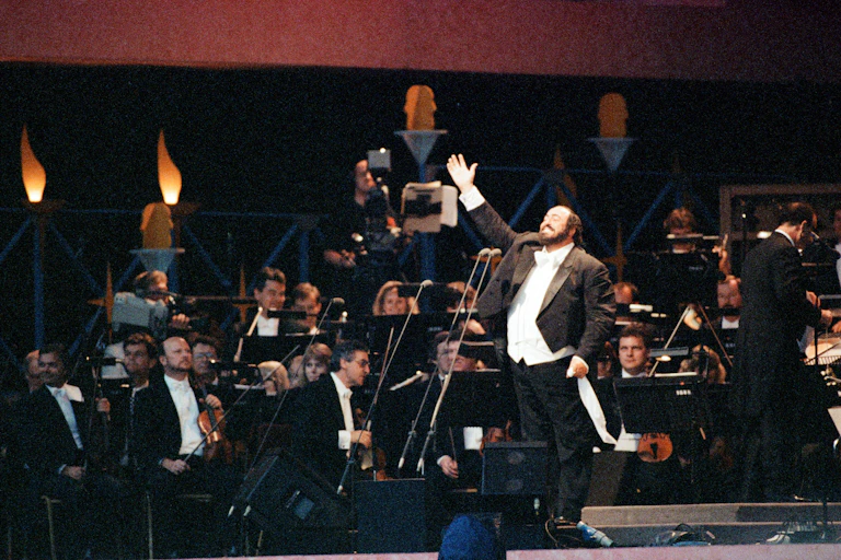 An male opera singer in evening dress taking a bow at a concert.