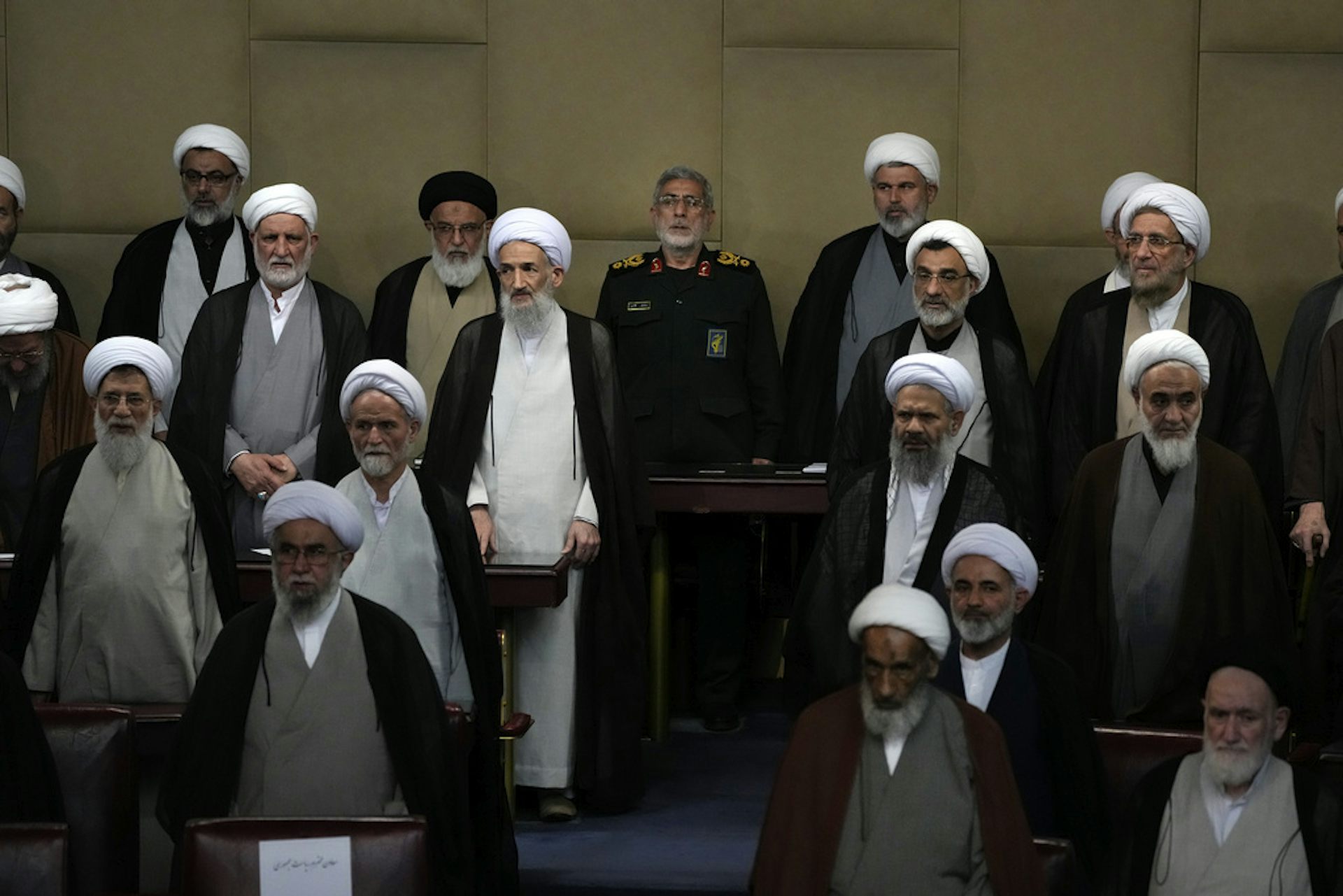 A group of men in Shia Muslim religious attire gather at a political forum.