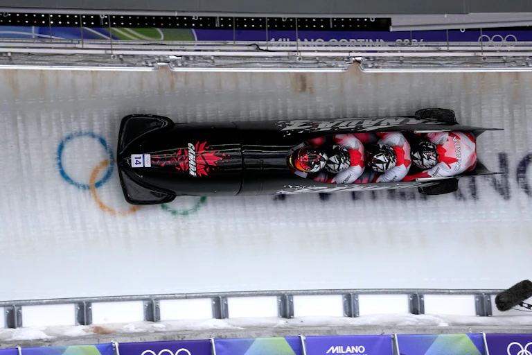 Des athlètes dévalent la piste lors d'une épreuve de bobsleigh à quatre