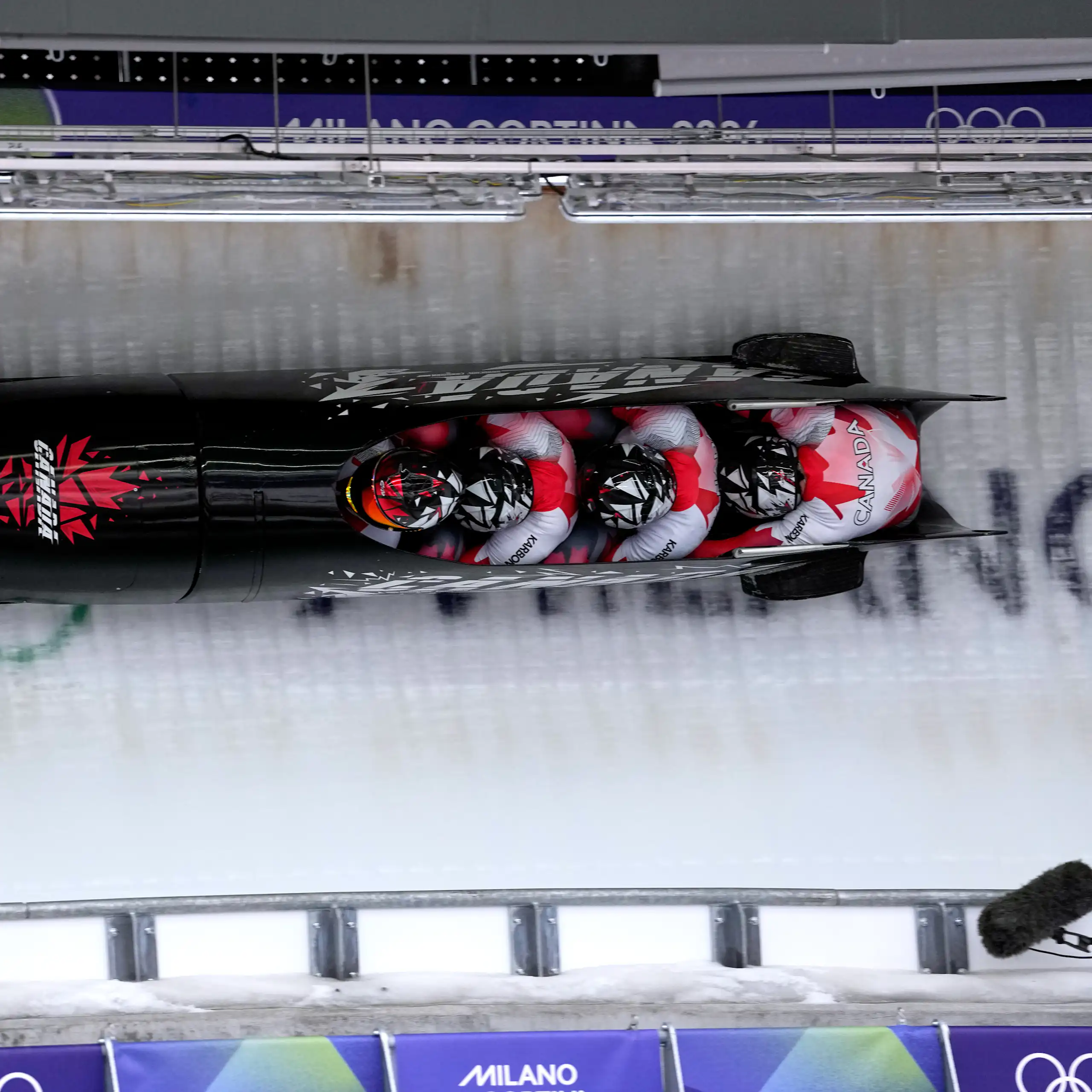 Des athlètes dévalent la piste lors d'une épreuve de bobsleigh à quatre