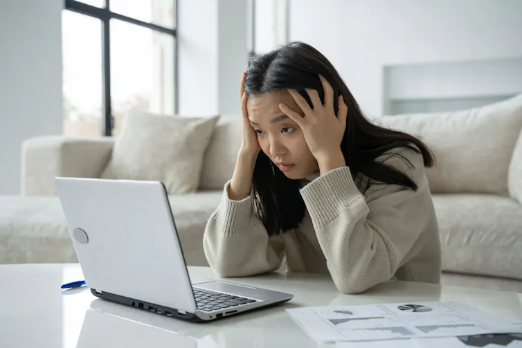 Woman stares at laptop screen.