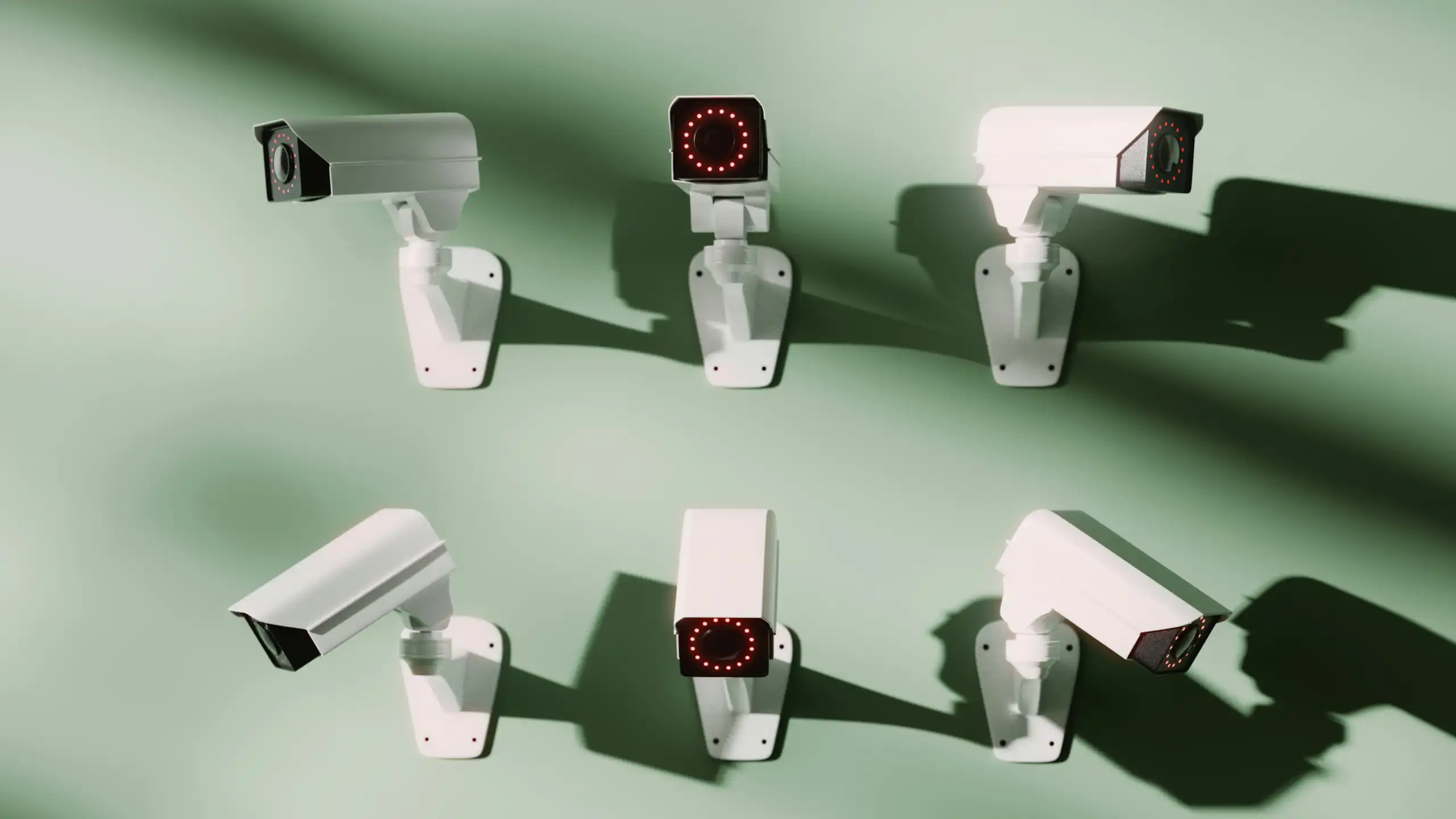 Six surveillance cameras hanging on a wall.