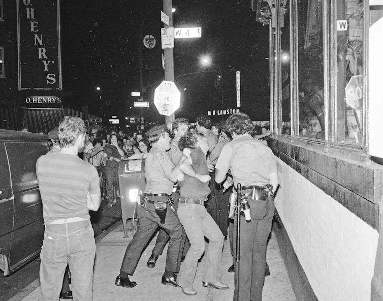A sidewalk scuffle where police are seen apprehending a protester.