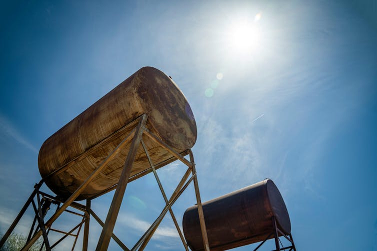 Rusty small fuel tanks seen against the sky.