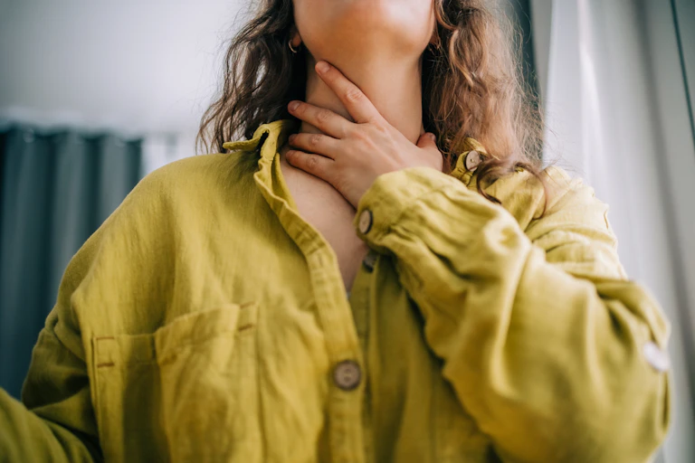 Woman holds her throat