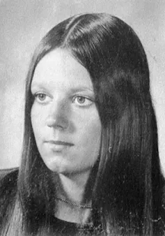 A black and white portrait of a young woman with long, straight brown hair.